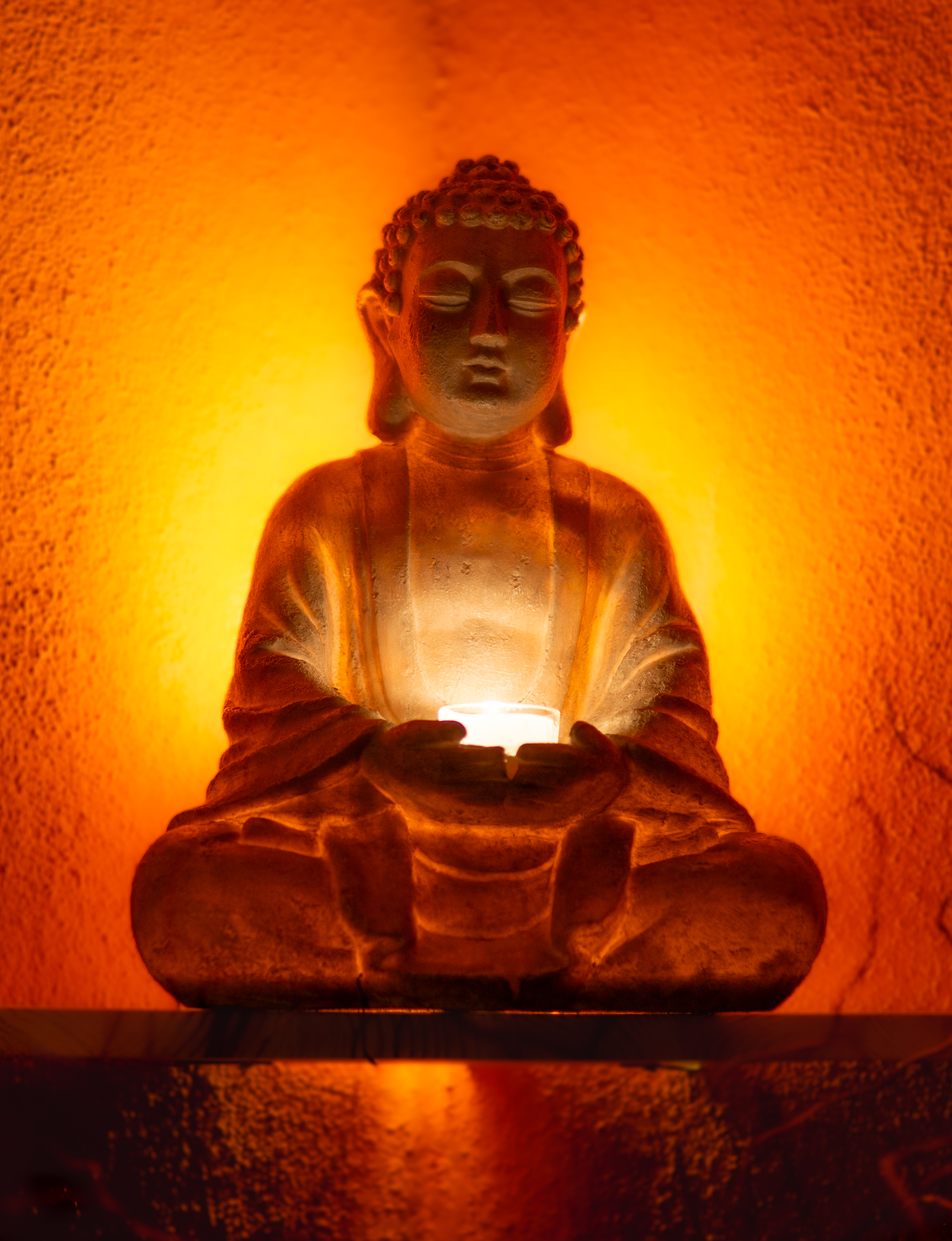 Buddha-Figur mit Kerzenlicht im Behandlungsraum